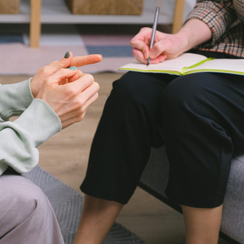 Close-up of a therapy session with a notebook and gestures indoors.